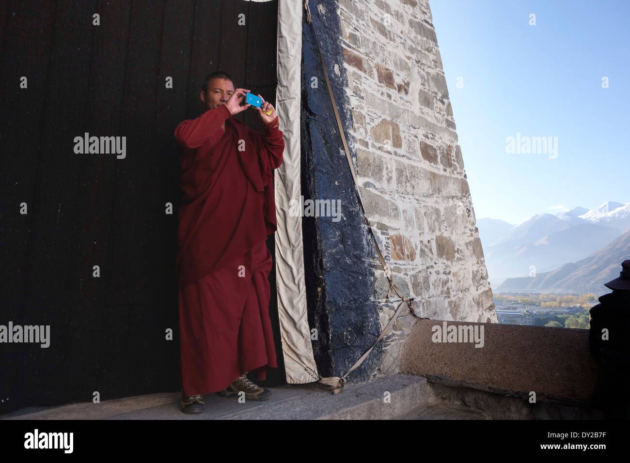 Buddhistischer Mönch in Tibet unter Bild mit i-Phone, Candid Straßenfotografie, Leben der buddhistischen Hingabe Stockfoto