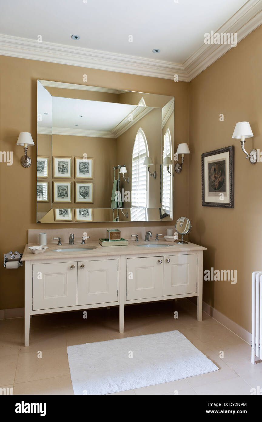 Eine doppelte Kalkstein gekrönt Unterschrank im Bad unter einem großen Spiegel von Andrew Kenyon geliefert Stockfoto