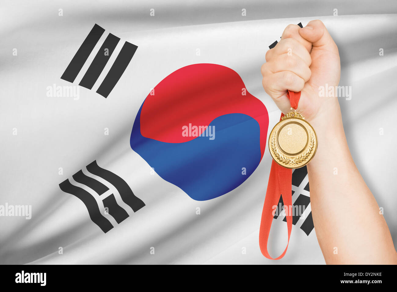 Sportler halten Goldmedaille mit Flagge auf Hintergrund - Südkorea Stockfoto