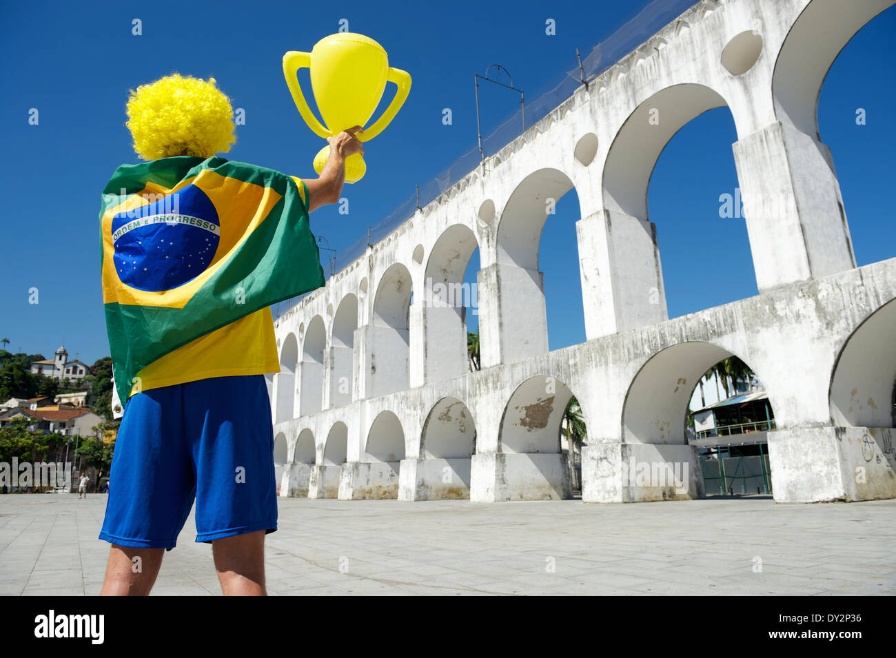 Mann in Brasilien Flagge hält Trophäe über Arcos da Lapa Bögen Rio De Janeiro Brasilien Stockfoto