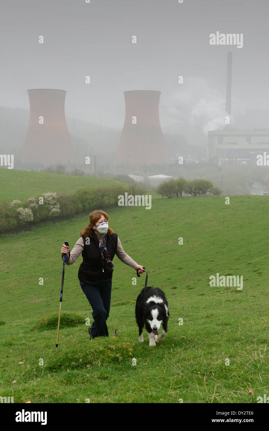 Frau mit Smog-Maske während des Gehens Hunde in der Nähe von Ironbridge Kraftwerk wegen Smog Umweltverschmutzung in UK Stockfoto
