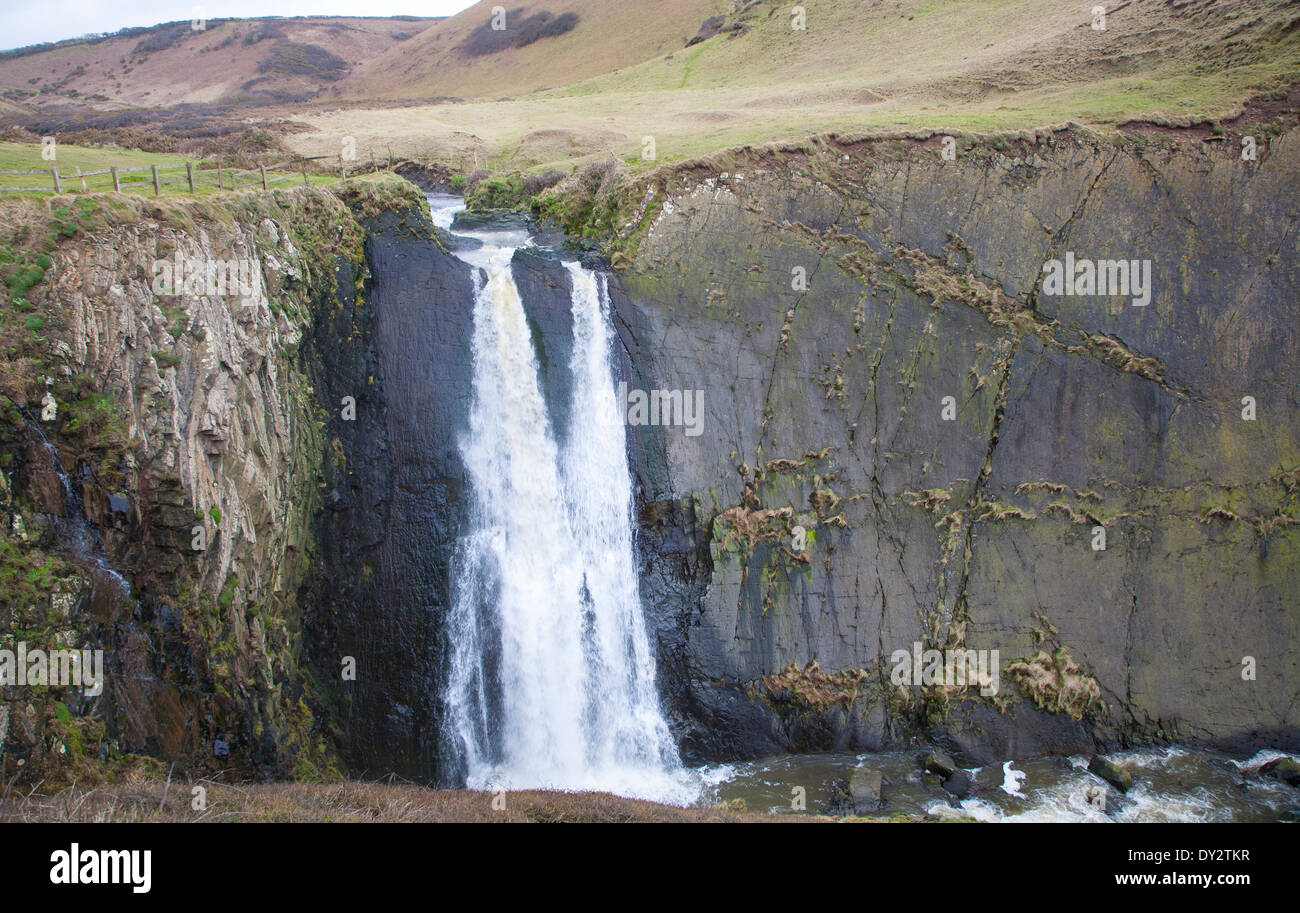 Speke Mühle Mund Wasserfall als Wasser-Kaskaden über steile Klippe in der Nähe von Hartland Quay, North Devon, England Stockfoto