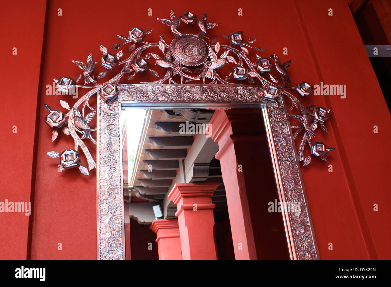 Reich verzierte Metallspiegel und Rahmen auf roten Wand, Oaxaca, Mexiko Stockfoto