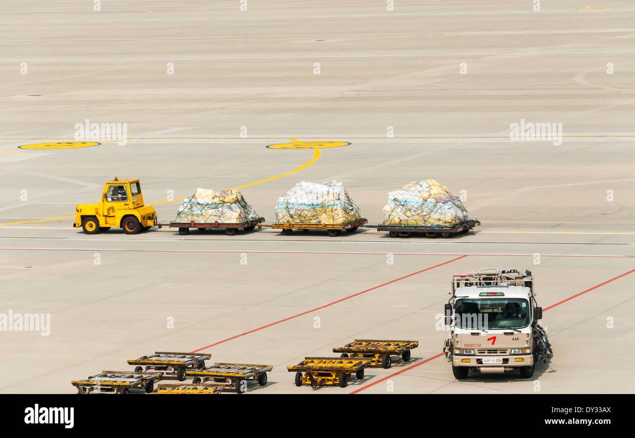 Ein Gepäck-Träger schleppen Gepäck zum Terminal. Stockfoto