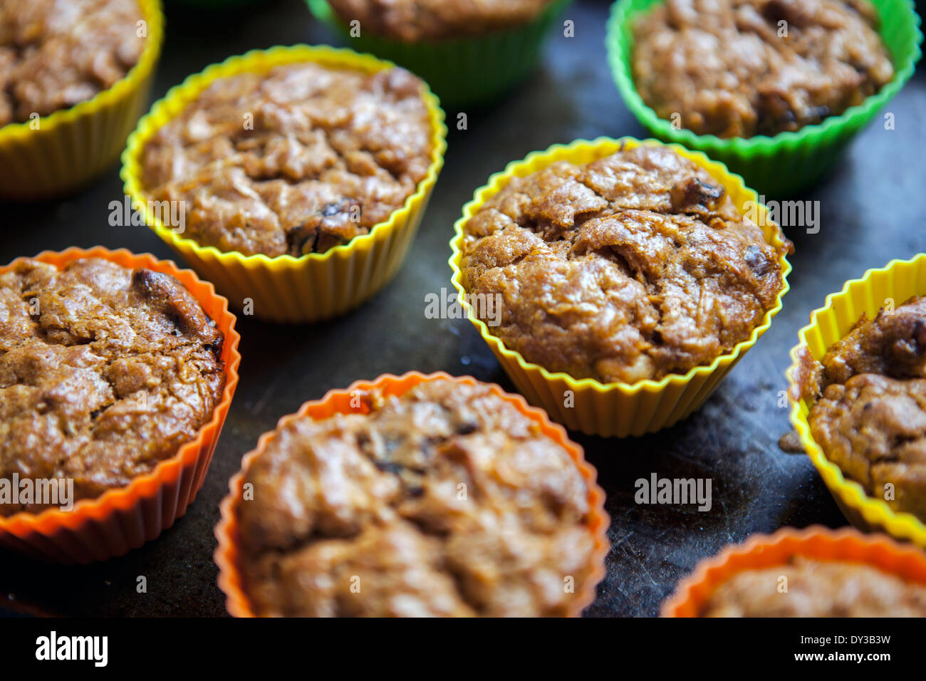 Nur gebackenen Muffins in bunten Silikonformen Stockfoto