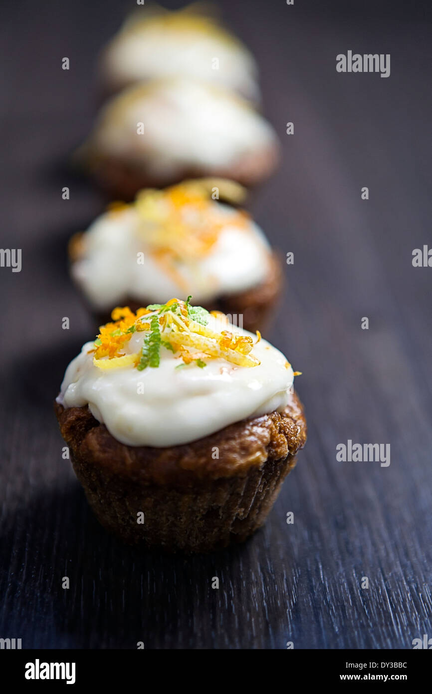 Linie von Cupcakes unscharf vor einem dunklen Hintergrund bewegen. Stockfoto