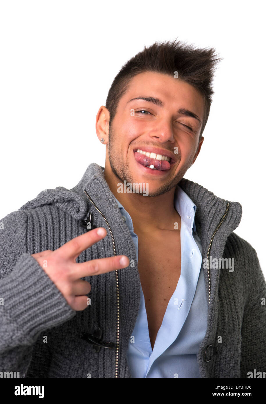 Attraktive junge Mann lächelnd mit Zungenpiercing, Victory-Zeichen mit zwei Fingern zu tun Stockfoto