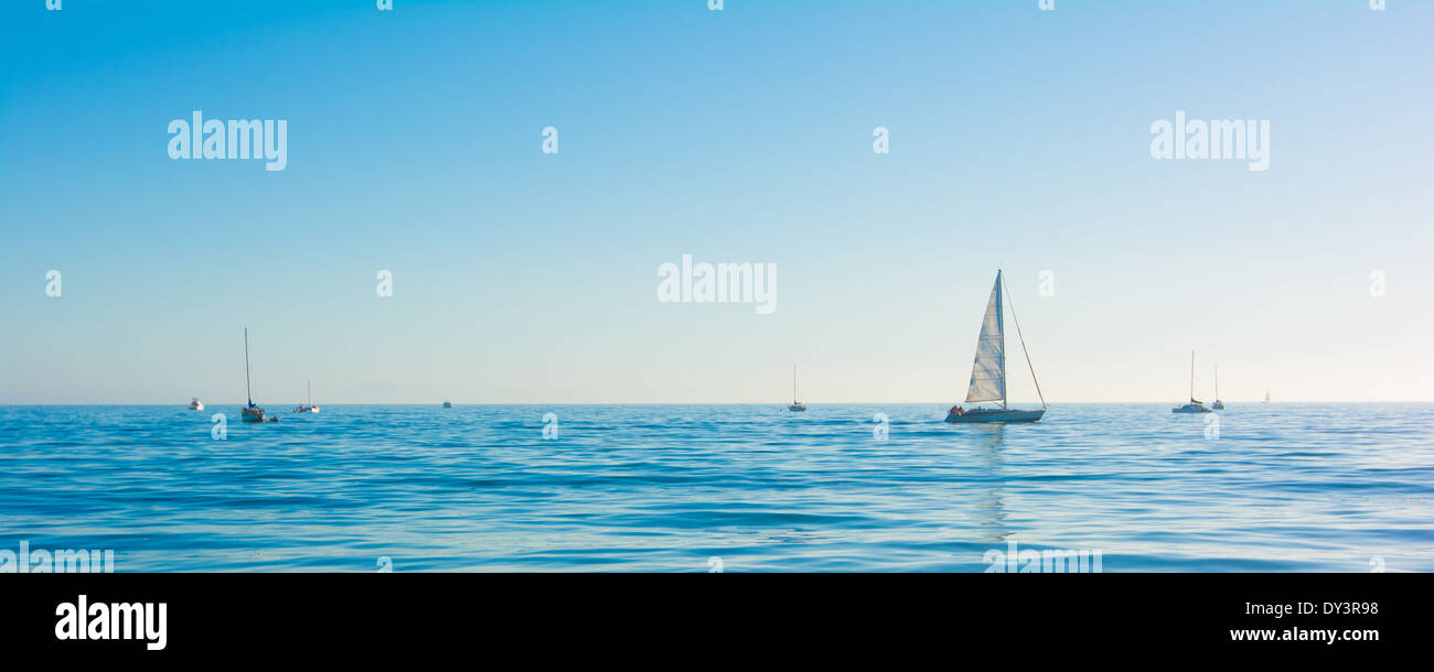 Ein Segelboot auf ein blaues Meer mit dem Himmel im Hintergrund Stockfoto