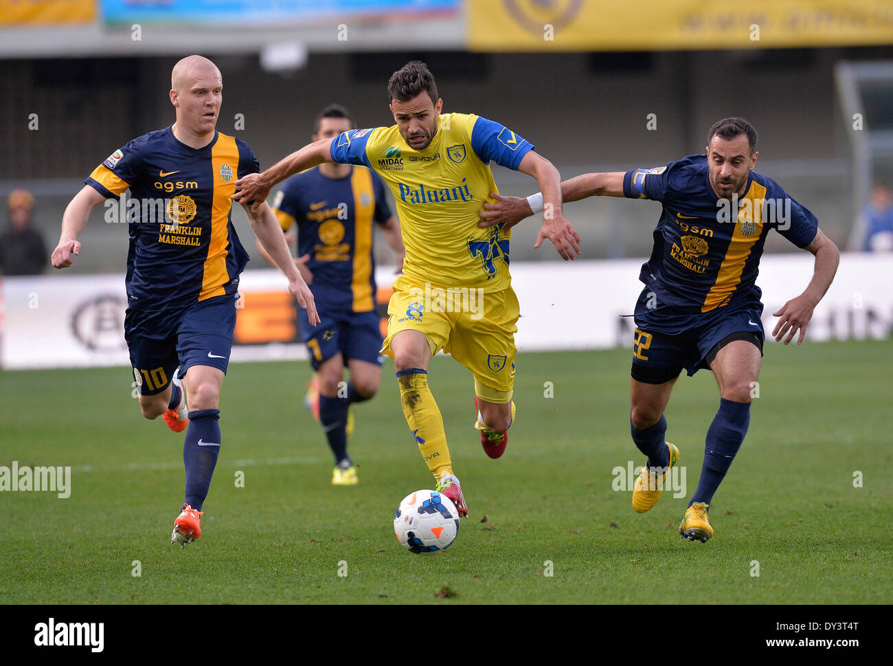 (140406)--VERONA, 6 April, 2014(Xinhua)--Veronas Emil Hallfredsson (L) und Domenico Maietta (R) wetteifern mit Chievo Ivan Radovanovic während der italienischen Serie A-Fußballspiel in Verona, Italien, 5. April 2014. Verona hat das Spiel 1: 0 gewonnen. (Xinhua/Alberto Lingria) Stockfoto