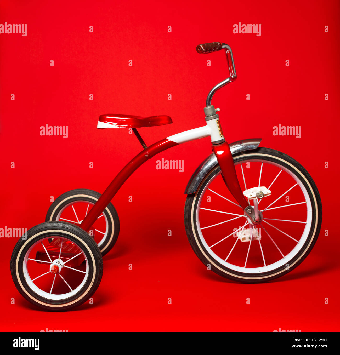 Ein Vintage rot Dreirad auf einem leuchtend roten Hintergrund Stockfoto