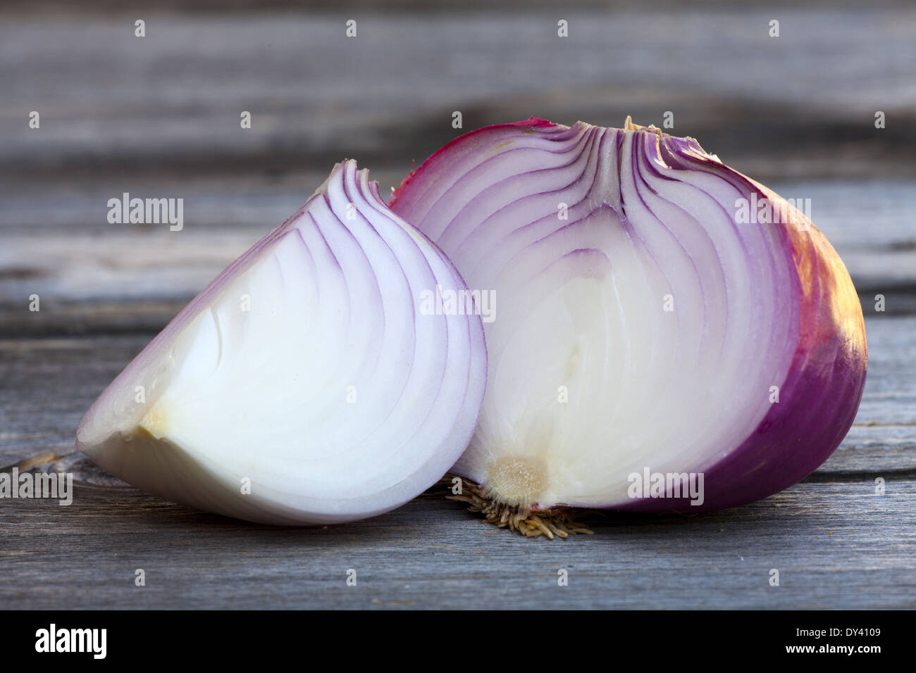 Nahaufnahme von zwei halbierte frischen roten Zwiebeln auf einem alten Holztisch Stockfoto