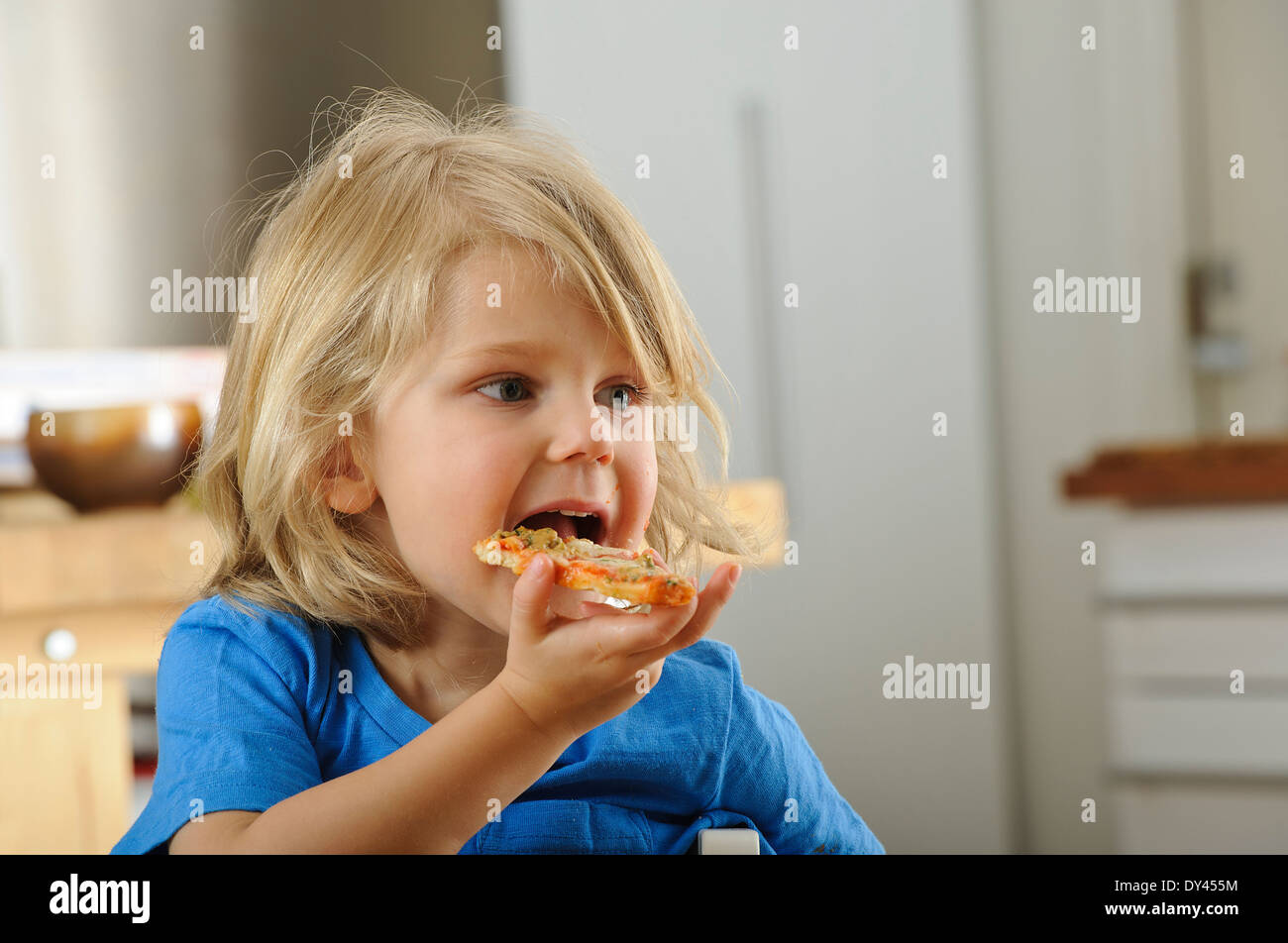 Junge genießt ein Stück pizza Stockfoto