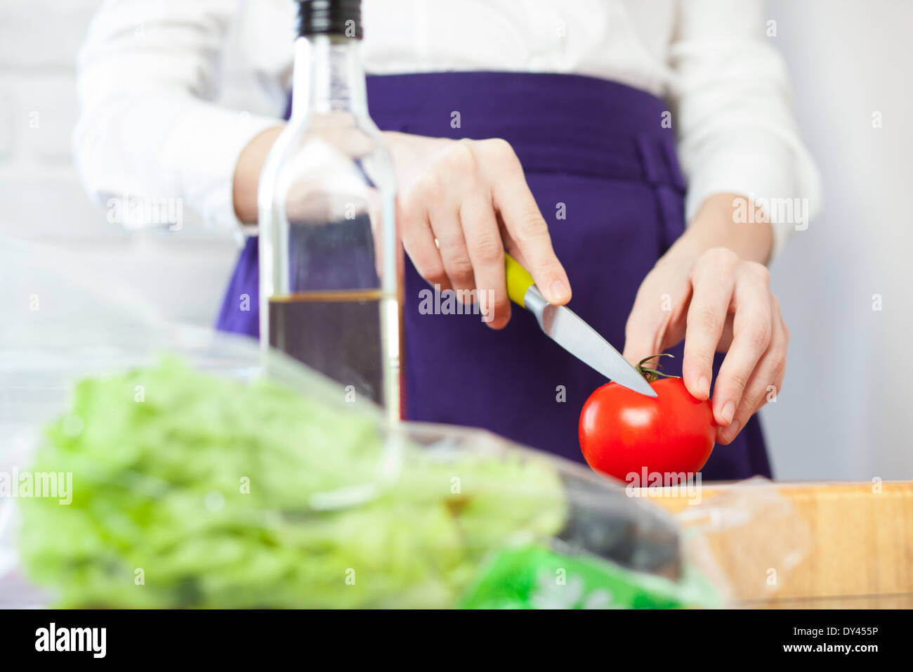 Köchin, eine Tomate Salat schneiden Stockfoto