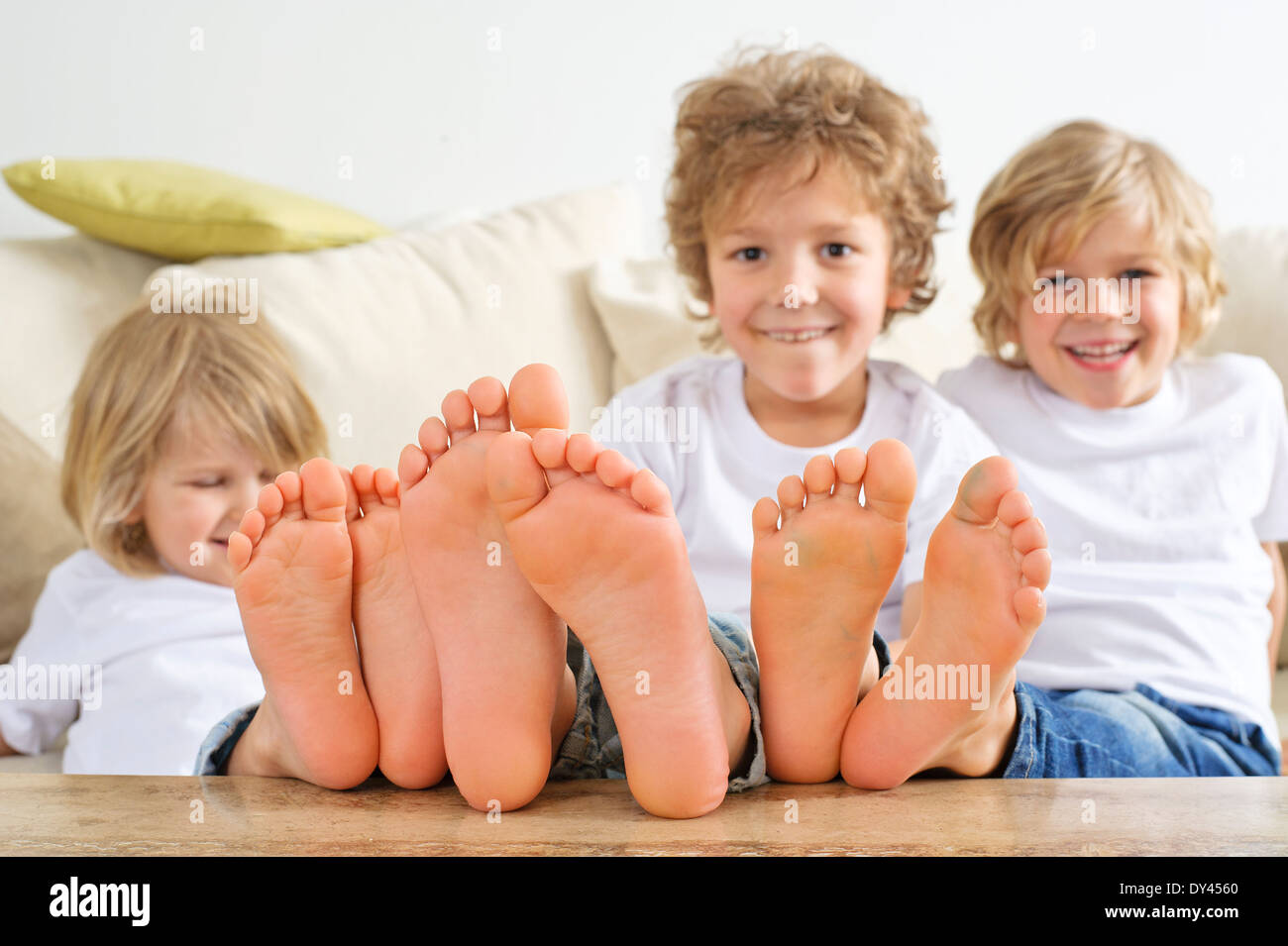 drei Jungs haben ihre Füße auf dem Tisch Stockfoto