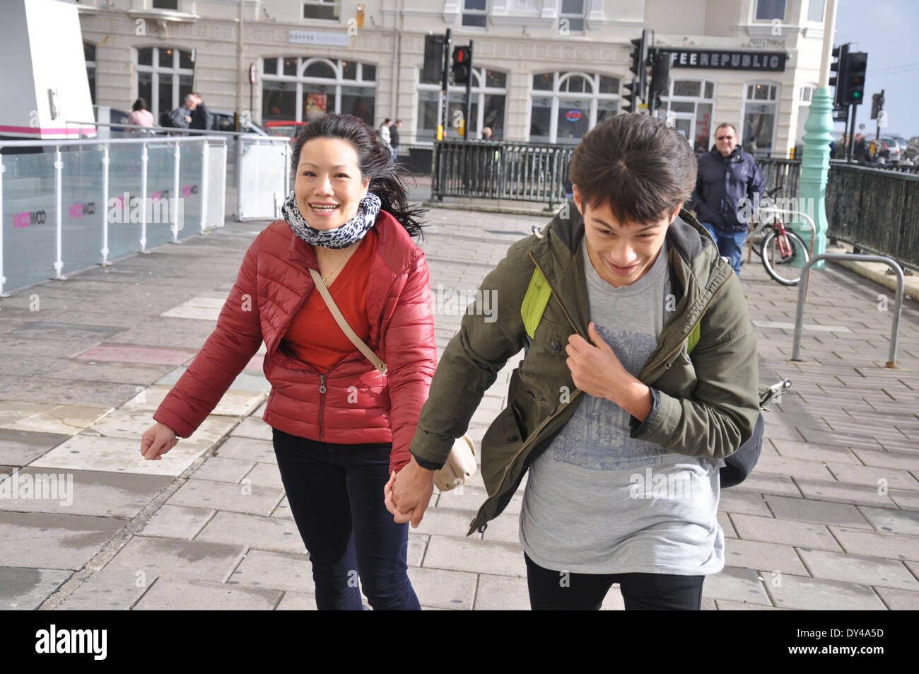 Asiatische vietnamesische Mutter und Sohn gehen in den Wind in Brighton, UK Stockfoto
