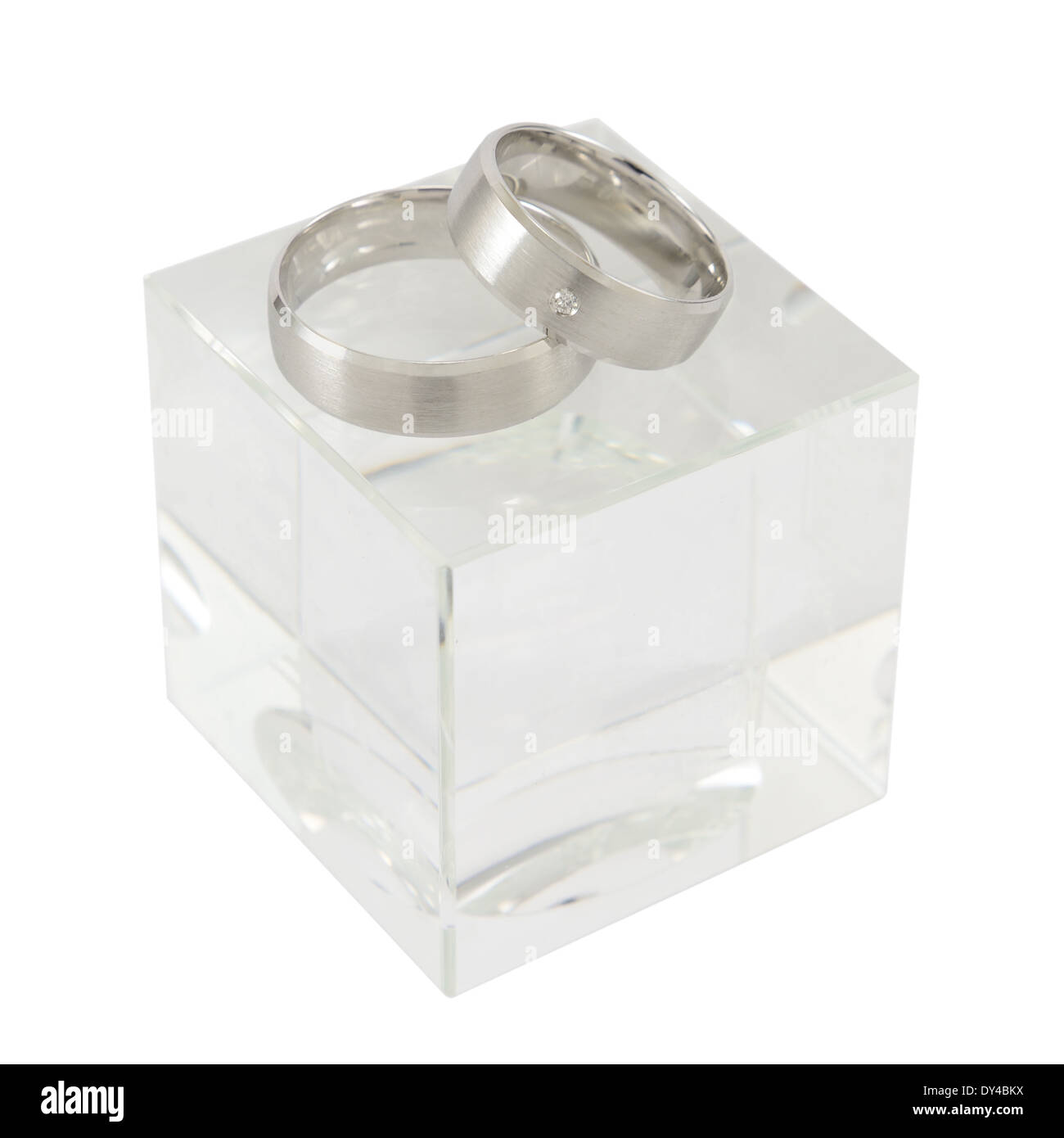 Ein paar Weißgold Ringe auf kubischen Glas isoliert auf weiss. Stockfoto