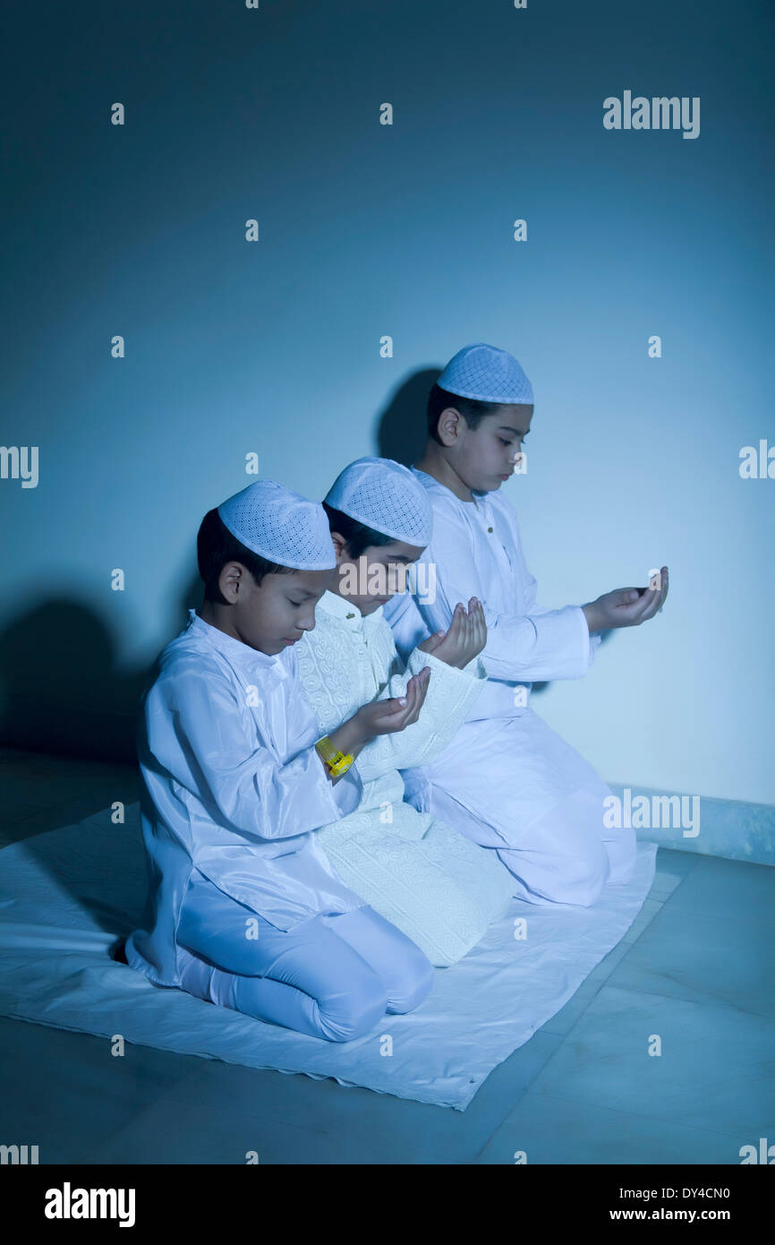 Indische muslimische Kinder sitzen und Prayering Stockfoto
