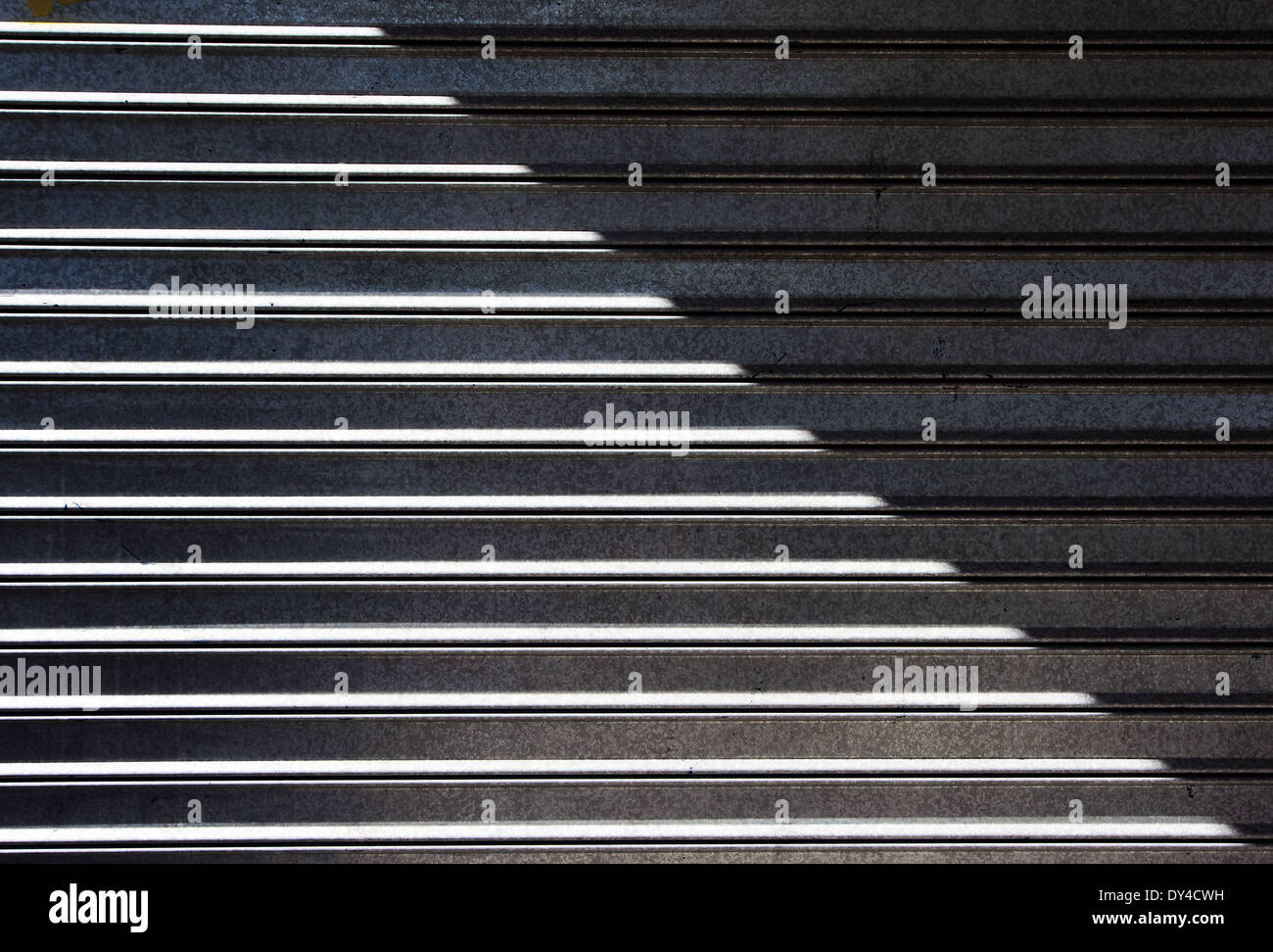Hintergrund der Garage metallischen Rollladen mit Sonnenlicht und Schatten Stockfoto