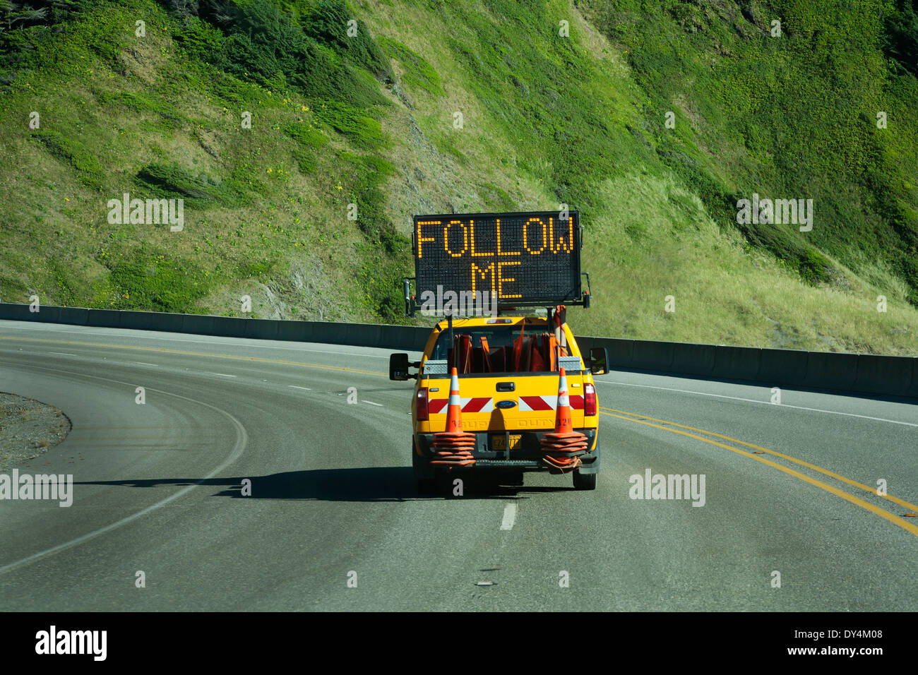 Straßenbau weiter befolgen Sie den pilot LKW auf einer Straße durch die Berge. Leuchtreklame sagt folgen mir. Stockfoto