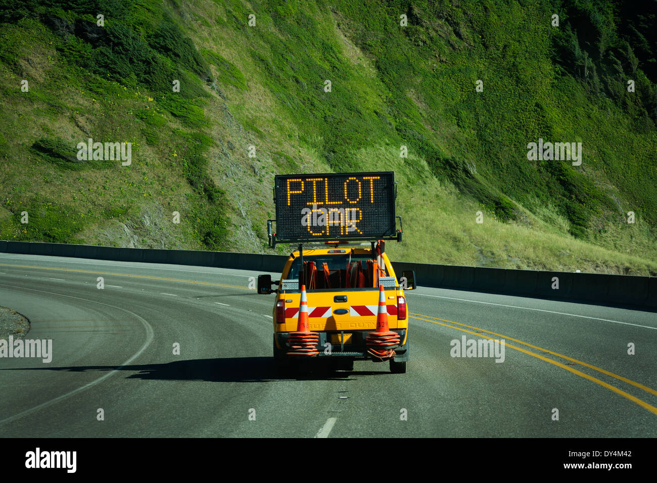 Straßenbau weiter befolgen Sie den pilot LKW auf einer Straße durch die Berge. Leuchtreklame sagt pilot Auto. Stockfoto