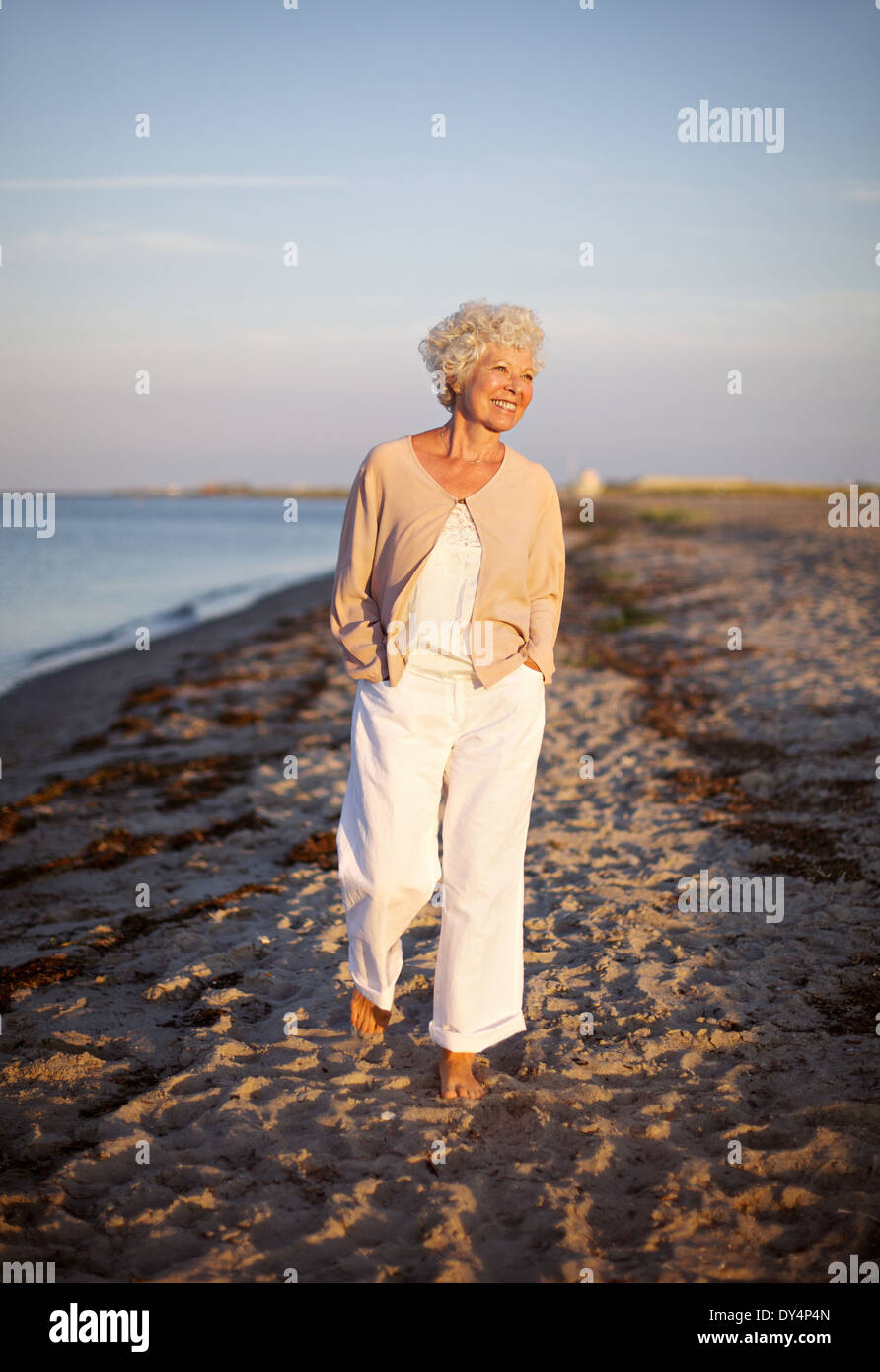 Bild der älteren Frau zu Fuß am Strand. Glücklich und entspannt kaukasischen Frauen spazieren am Strand. Stockfoto