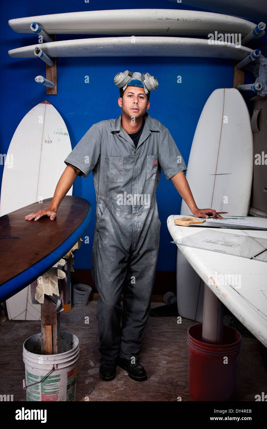 Porträt eines Mitte erwachsenen Mannes und Surfbretter in seiner Werkstatt Stockfoto