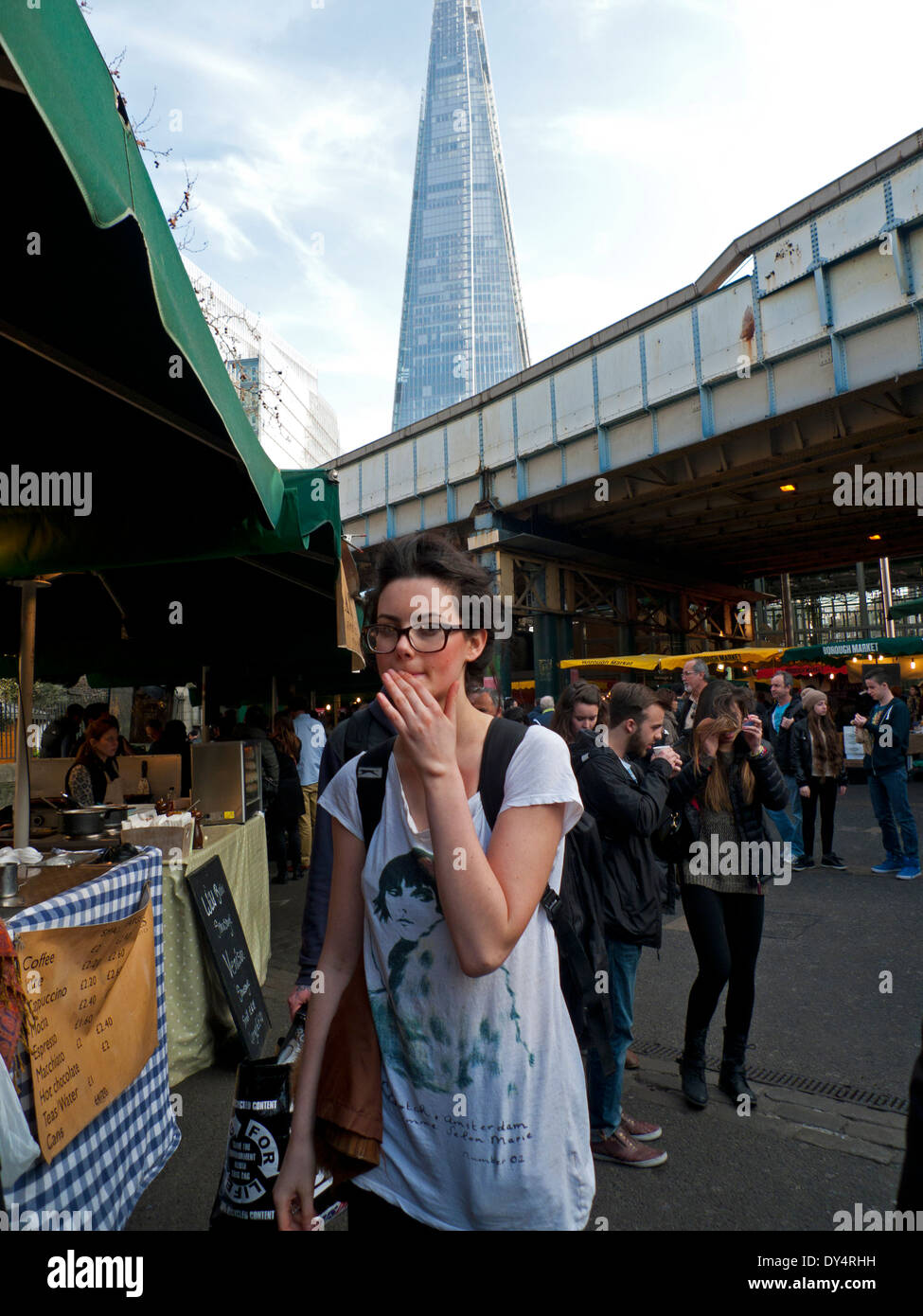 Junge Frau vorbeigehen Essen Stände durch die open-air-Gelände der Borough Market, London Bridge, London, UK KATHY DEWITT Stockfoto