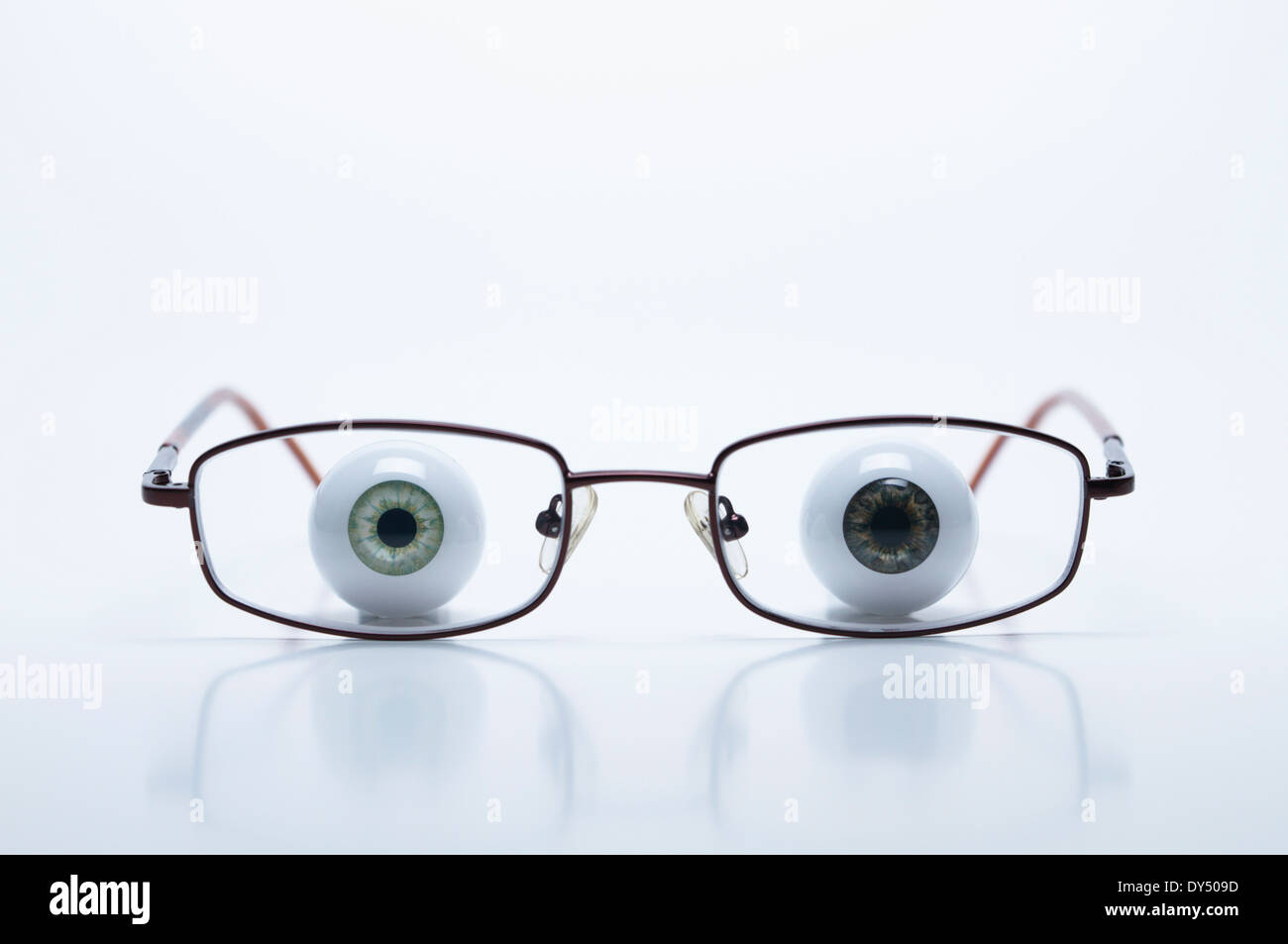 Modell-Augäpfel hinter Brille mit kurzsichtigen (negative) Linsen Stockfoto