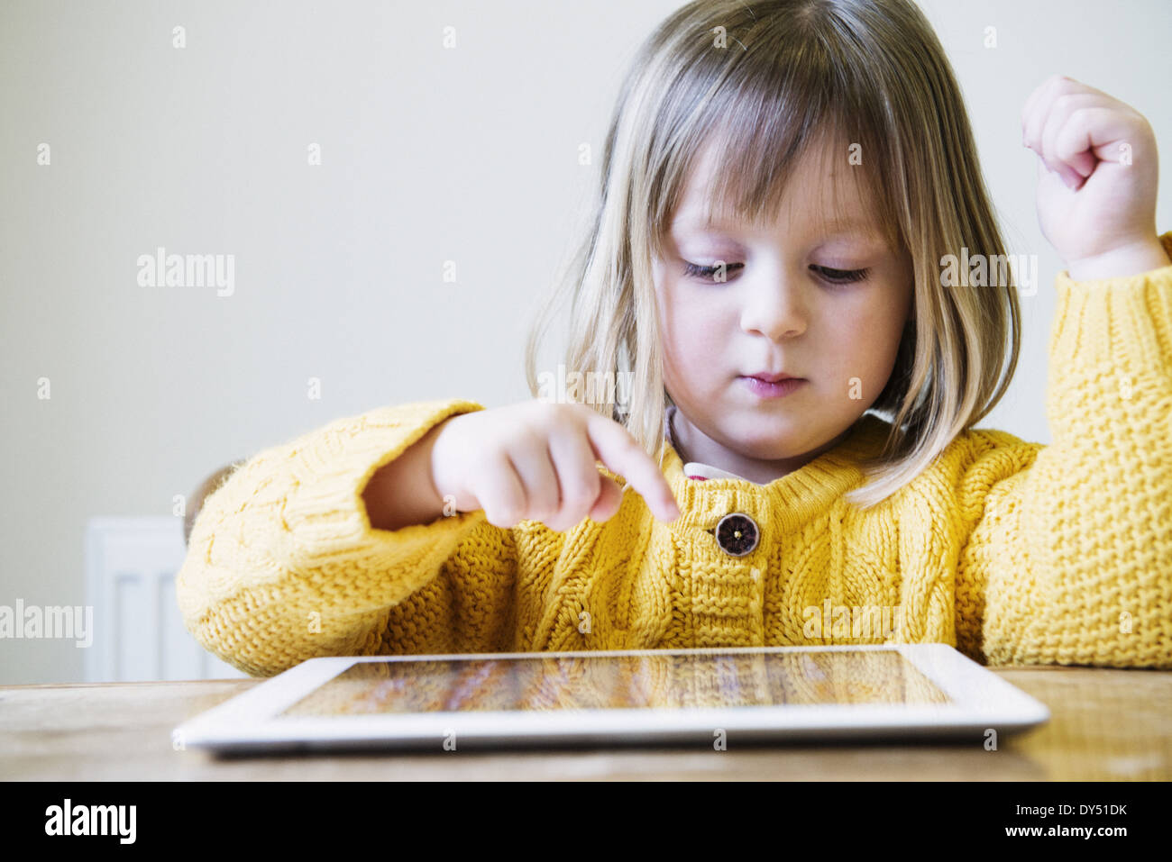 Junges Mädchen am Küchentisch mit digital-Tablette Stockfoto