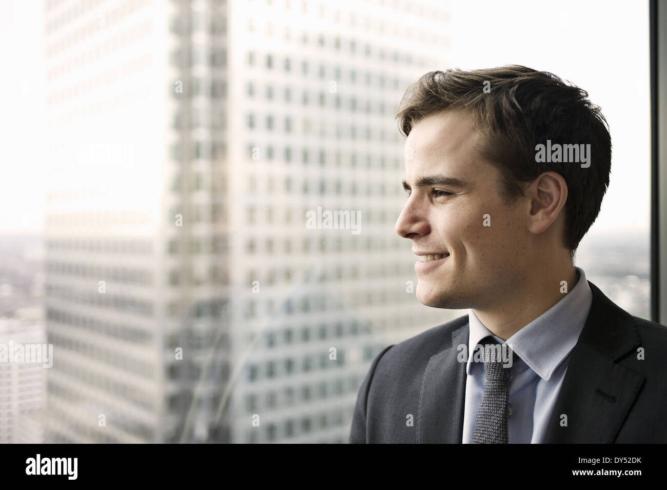 Porträt des jungen Geschäftsmann, der Blick aus dem Bürofenster Stockfoto
