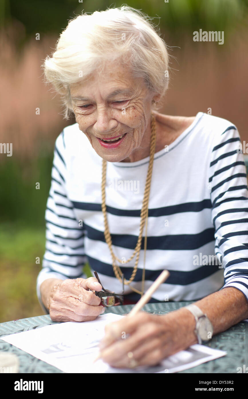 Ältere Frau Zeichnung im Ruhestand Villa Garten Stockfoto