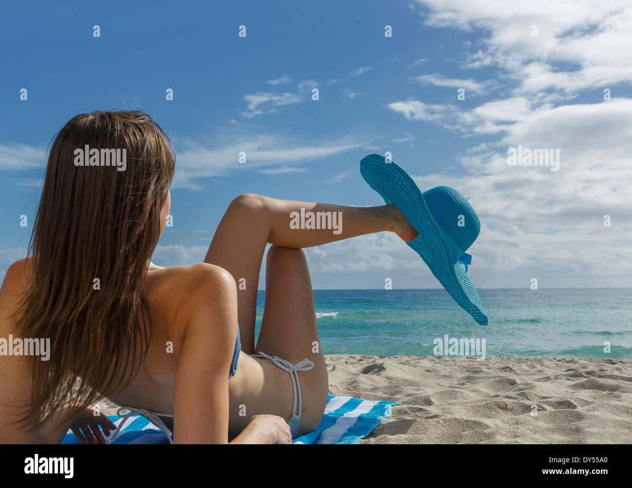 Junge Frau entspannen am Strand mit blaue Sonnenhut Stockfoto