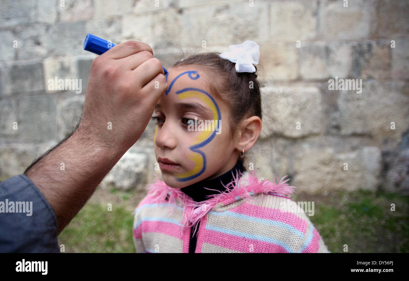 Jerusalem, Jerusalem, Palästina. 7. April 2014. Ein palästinensisches Mädchen hat auf ihrem Gesicht gemalt, während einer Feier anlässlich Internationaler Kindertag in Jerusalem am 7. April 2014 Credit: Saeed Qaq/APA Images/ZUMAPRESS.com/Alamy Live News Stockfoto