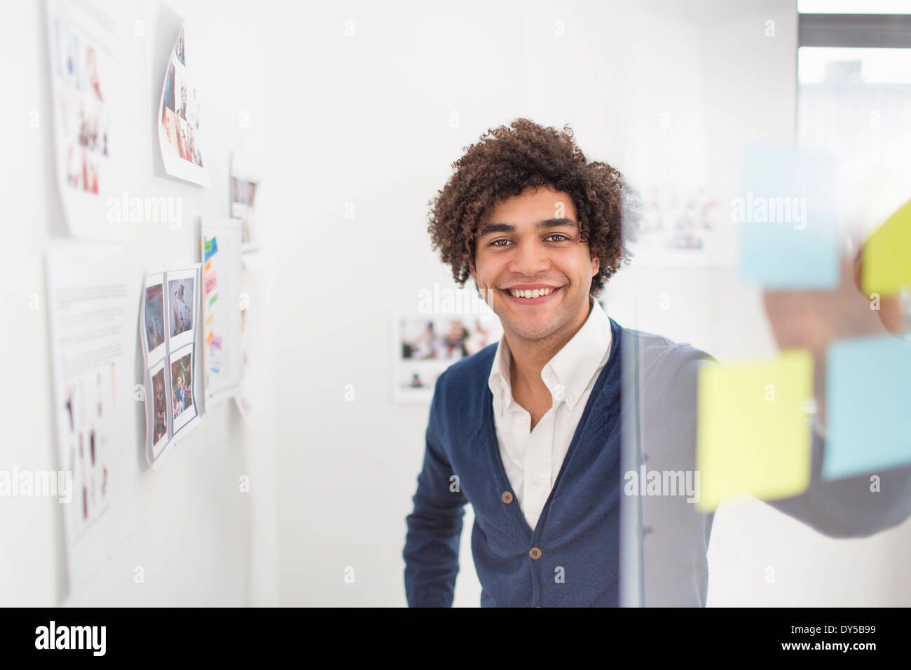 Junger Mann mit Klebstoff Noten, Lächeln Stockfoto