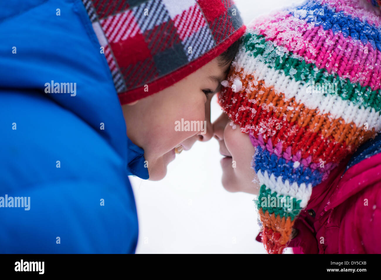 Bruder und Schwester von Angesicht zu Angesicht im Schnee Stockfoto