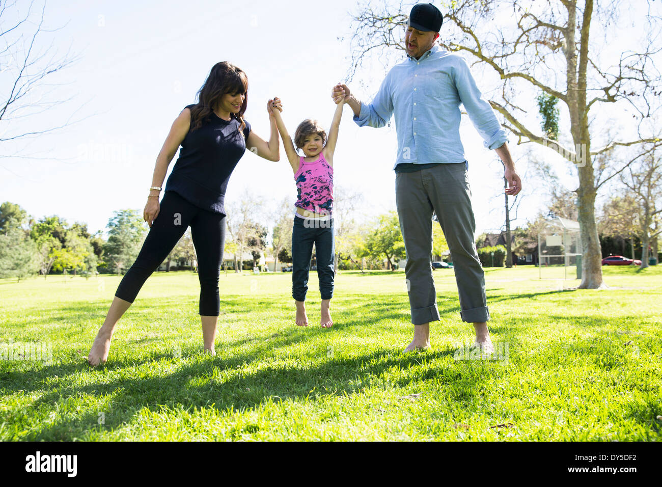 Mitte erwachsenes paar junge Tochter im Park anheben Stockfoto