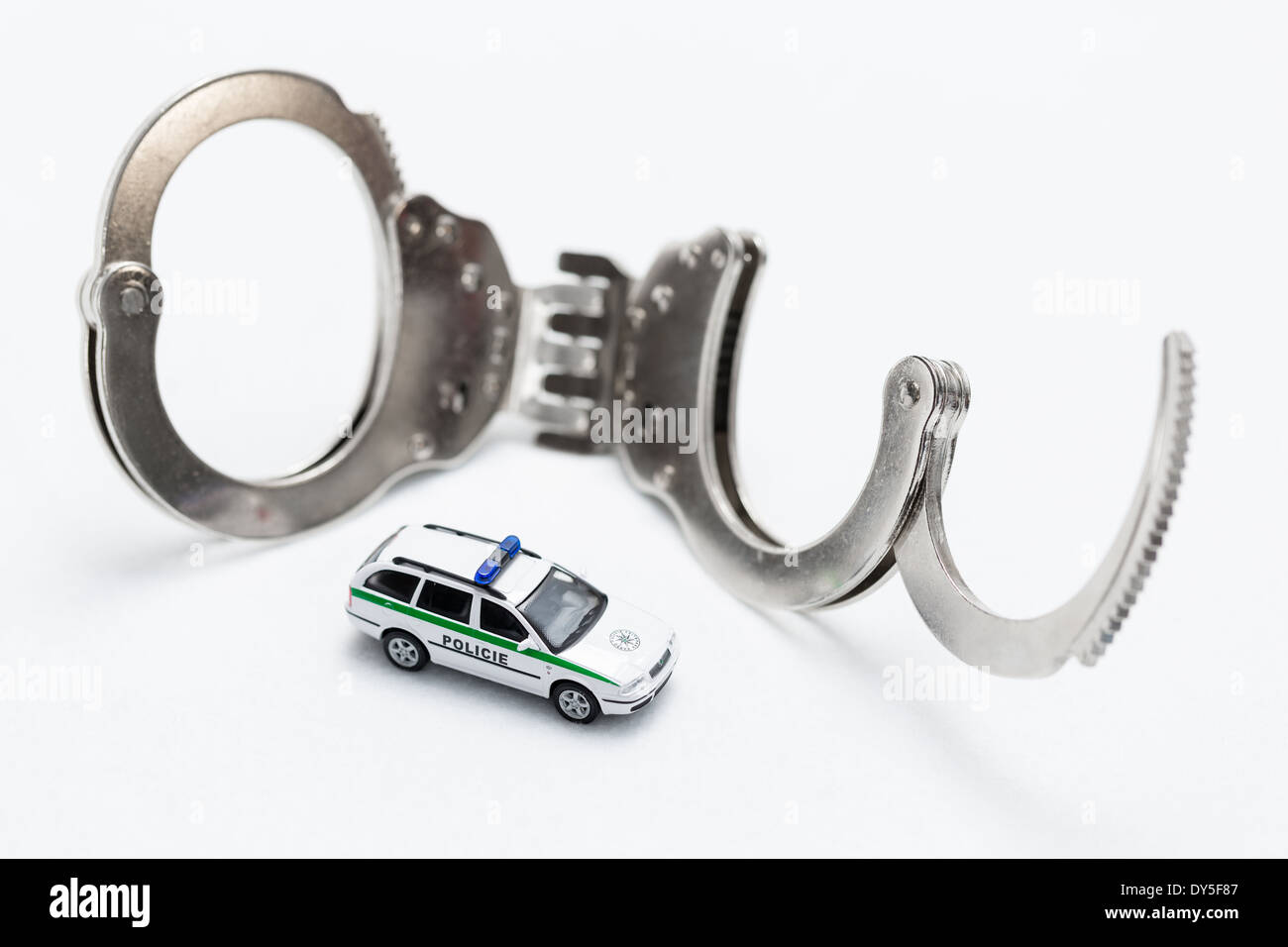 Fesseln mit Modell der Polizeiwagen auf weißem Hintergrund Stockfoto