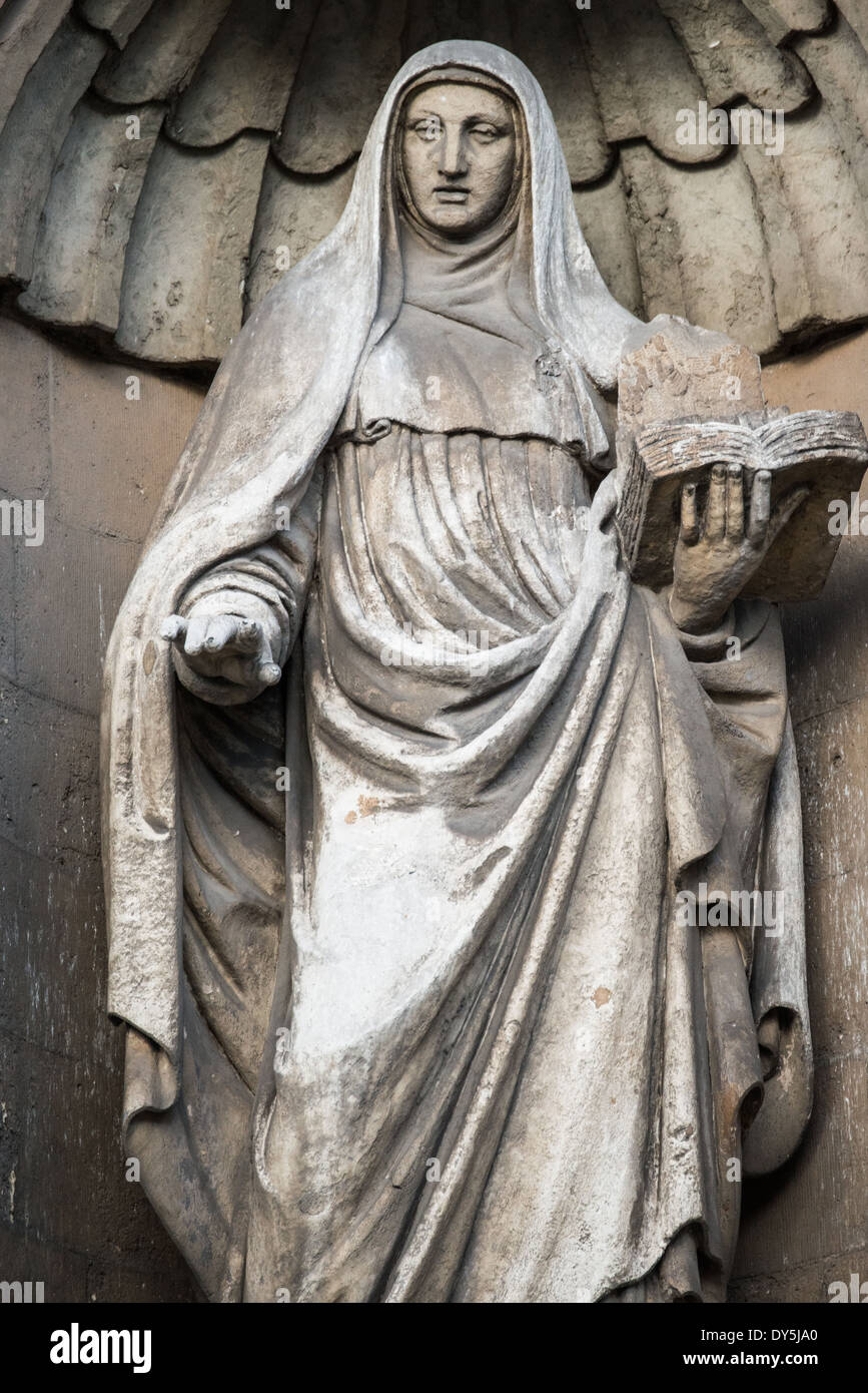 Kirche des Heiligen Johannes des Täufers Brüssel Belgien // BRÜSSEL, Belgien — Eine religiöse Statue ziert die Kirche des Heiligen Johannes des Täufers in der Béguinage und zeigt Merkmale der flämischen Barockskulptur aus dem 17. Jahrhundert. Dieses dekorative Element stellt einen Teil der ursprünglichen barocken Ornamentik der Kirche dar. Die Statue veranschaulicht die künstlerischen Traditionen religiöser Skulpturen in historischen Brüsseler Kirchen. Stockfoto