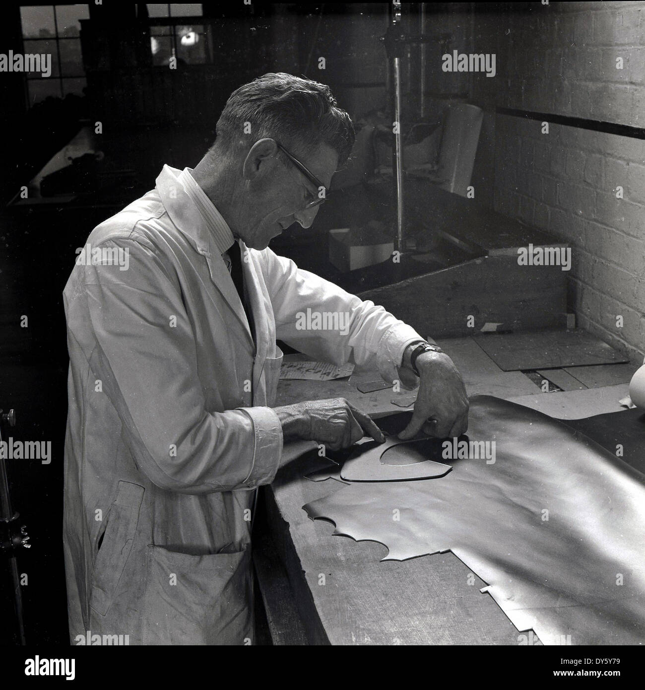 1950er, historisch, auf einer Werkbank, ein männlicher Arbeiter, der das Leder für die Herstellung von Schuhen bei der Glenfield Progress Co-operative Society Limited, einem Schuh- und Schuhgeschäft in Glenfield, Leicester, England, UK, auszeichnete, ein Unternehmen, das sich auf Frauen- und Kinderschuhe spezialisiert hat. In der Vergangenheit war Leicestershire ein wichtiges Gebiet Großbritanniens für die Schuhherstellung, und 1872 begann die Co-operative Wholesale Society mit der Herstellung von Schuhen. Stockfoto