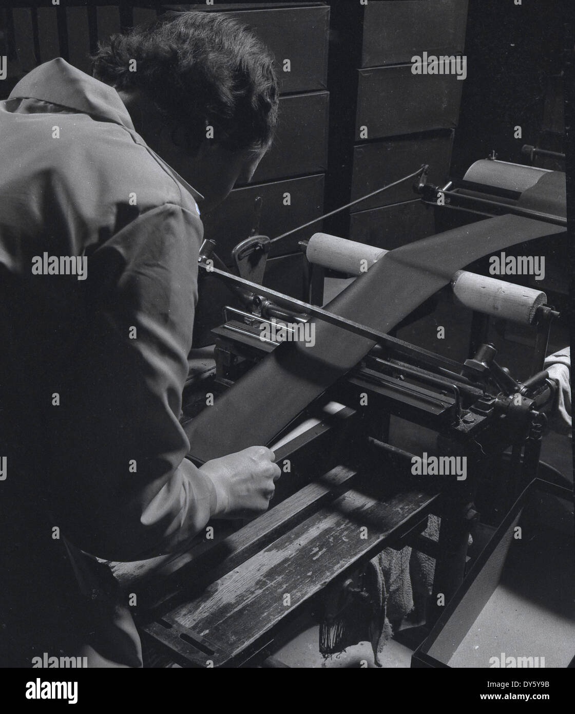 1950er, historisches Bild einer Arbeiterin, die bei der Glenfield & District Co-Op Services Society, Schuh- und Schuhmacher, Leicester, England, UK, Leder für Schuhe mit einer Maschine der Epoche formte. Seit dem 19. Jahrhundert wurde Leicester zu einem wichtigen Zentrum für die Schuhherstellung, insbesondere in Frauen- und Kinderschuhen, und 1872 begann die Co-operative Großhandelsgesellschaft in Leicester mit der Herstellung von Schuhen und Schuhen. Stockfoto