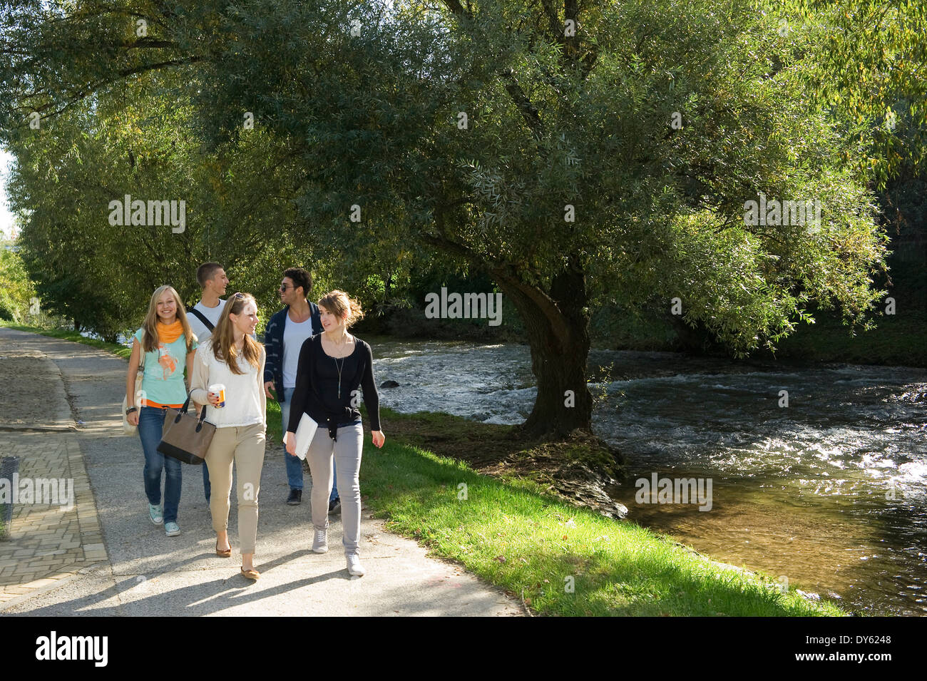 Junge Menschen zu Fuß entlang dem Fluss Dreisam, Freiburg Im Breisgau, Schwarzwald, Baden-Württemberg, Deutschland Stockfoto