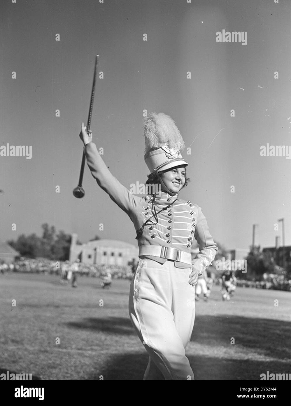 Eine Trommelmajorette aus Tyler, Texas, die eine Marschband bei einer Universitäts-Fußballveranstaltung leitet. Dieses Foto zeigt den Geist von Collegefeiern und sportlichen Traditionen, insbesondere an der Texas A&M University und der University of Tulsa, wo Marschbands eine Schlüsselrolle spielen. Stockfoto