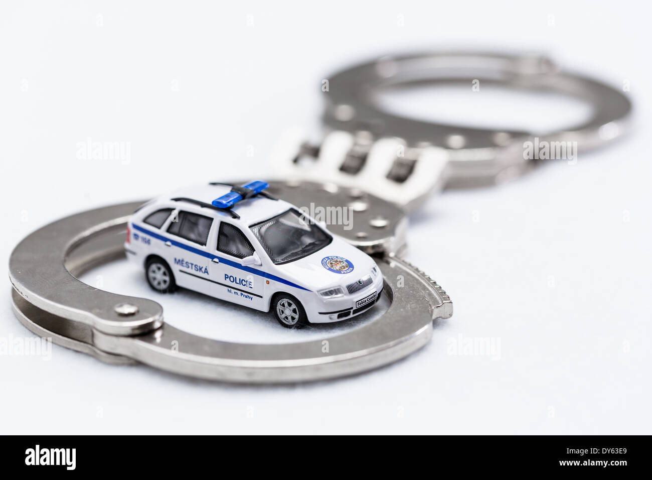 Fesseln mit Modell der Stadt Polizeiauto auf weißem Hintergrund Stockfoto