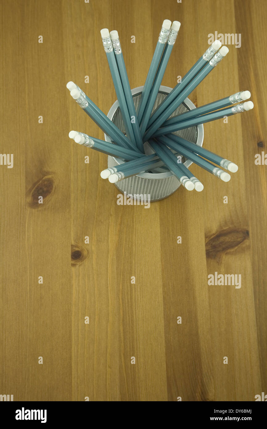 Erhöhten Blick auf eine Gruppe von blauen Stifte in einem Stifthalter auf einem Holztisch Stockfoto