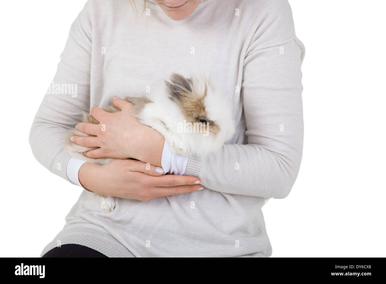 Kaninchen mit langen weißen Pelz auf dem Arm einer Frau Stockfoto