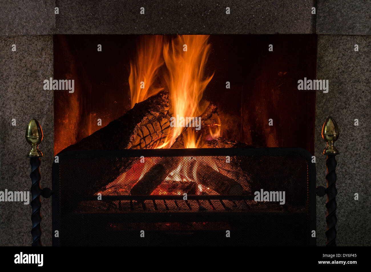 Gemütliches Feuer in einem Kamin aus Naturstein Stockfoto