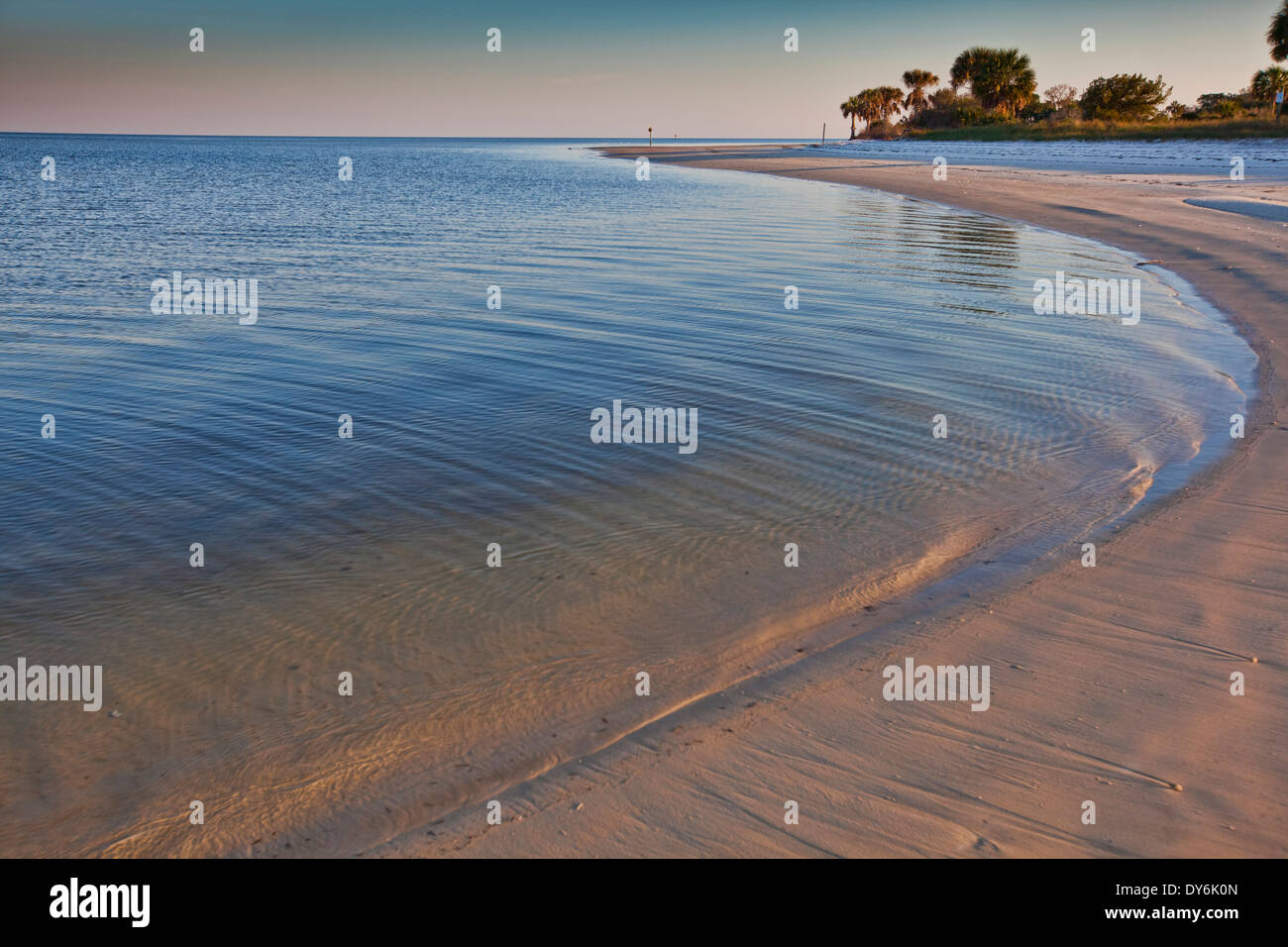 Gekrümmte Abschnitt des Strandes entlang einer geschützten Bucht am Golf von Mexiko mit späten Nachmittagssonne verlassen ein sanftes Leuchten auf dem sand Stockfoto