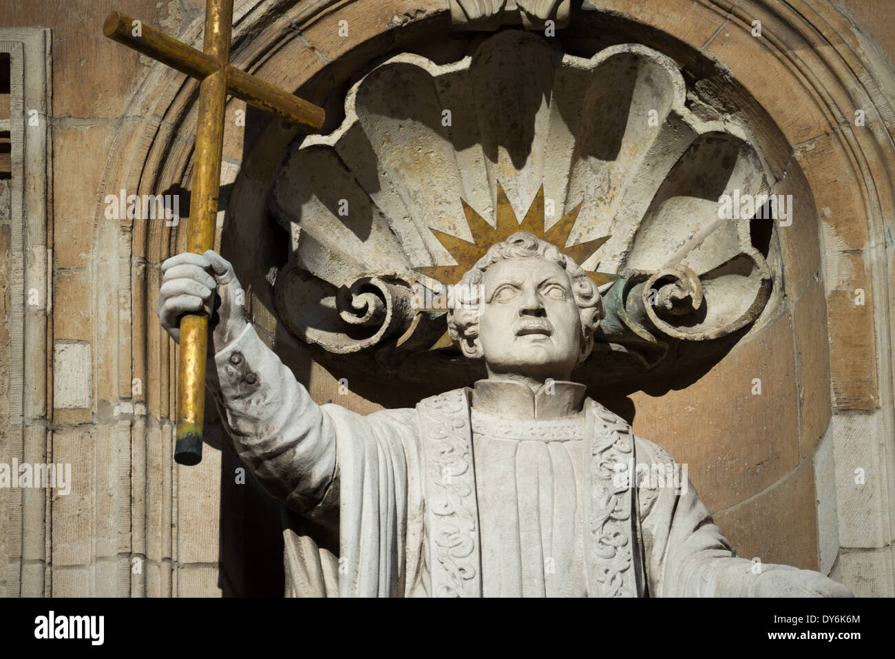 Religiöse Statue Kirche Äußere Brügge Belgien // BRÜGGE, Belgien — Eine religiöse Statue ziert das Äußere einer historischen Kirche in Brügge und demonstriert die reiche Tradition der kirchlichen Skulptur der Stadt. Das architektonische Detail veranschaulicht die Integration religiöser Kunst in die mittelalterliche Kirchengestaltung. Dieses dekorative Element repräsentiert die fortgesetzte Erhaltung des religiösen architektonischen Erbes Brügge. Stockfoto
