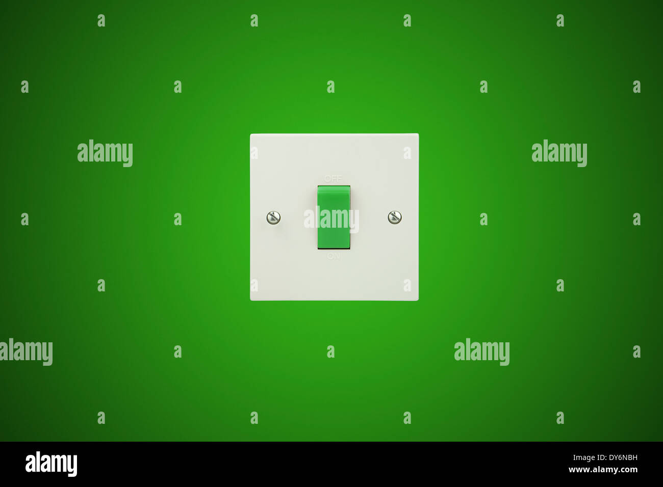 Grün-Schalter auf einem weißen Sockel und einen grünen Hintergrundwand Stockfoto