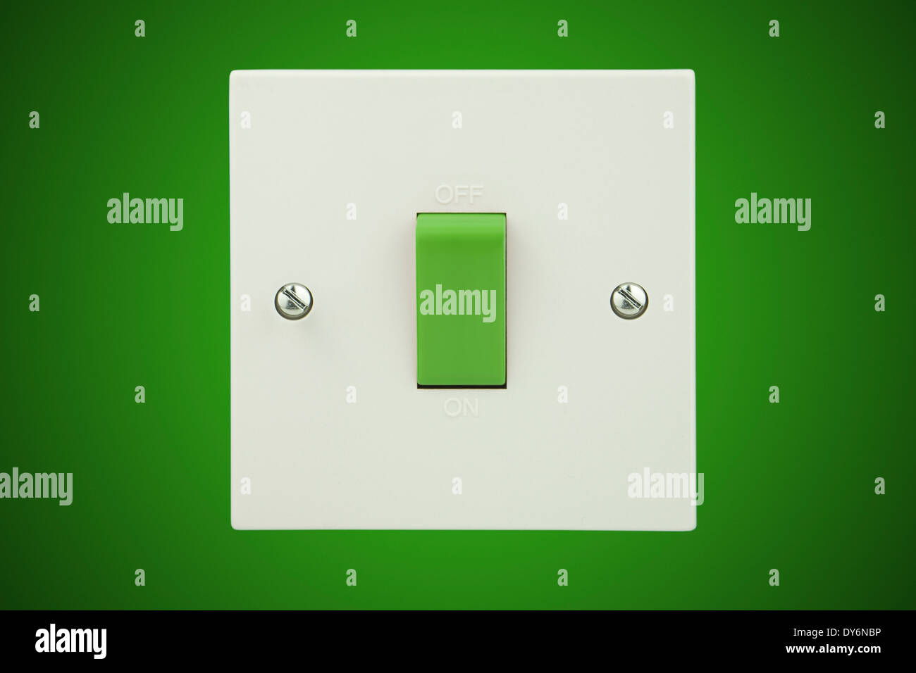 Grün-Schalter auf einem weißen Sockel und einen grünen Hintergrundwand Stockfoto